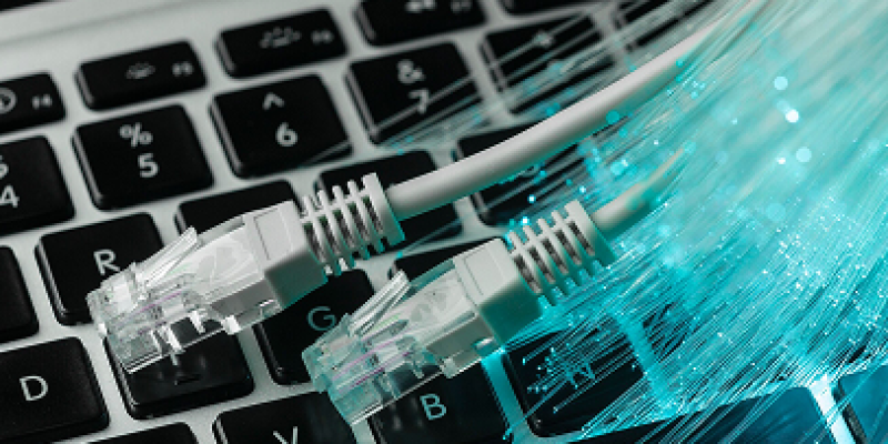 Blue optic fiber with ethernet cables and laptop